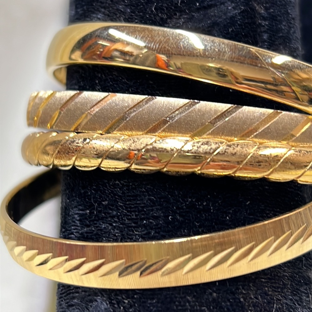 Monet vntg gold tone bracelets. 4 with smooth and etched finishes. Pre owned.